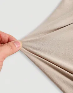 Detailed macro view showing the high elasticity and soft texture of beige knit fabric