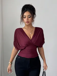 Detail shot of a burgundy deep V-neck top with flying sleeves and slim fit waist design.