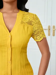 Close-up of yellow slim-fit top with delicate lace shoulders and button detail.