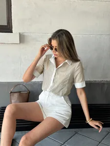 Detail view of a women's striped polo shirt with white contrast collar and cuffs