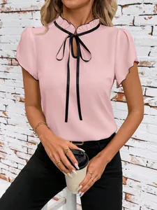 Close-up detail of a pink short sleeve blouse featuring a stylish black ribbon tie collar