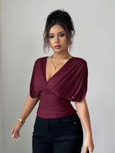 Elegant wine red deep V-neck ruched waist top for women shown in a professional studio setting
