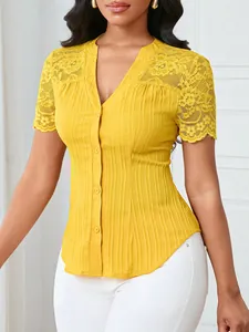 Detail shot of yellow slim-fit top featuring intricate lace embroidery and buttons