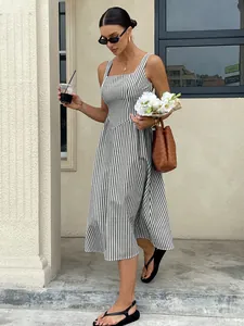 Woman wearing a French-style black and white striped sleeveless midi dress outdoors.