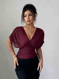 Detailed view of wine red deep V-neck blouse with elegant ruched waist design