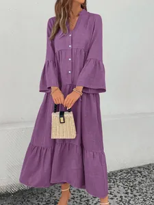 Detail view of a purple V-neck tiered dress with bell sleeves and button-up front