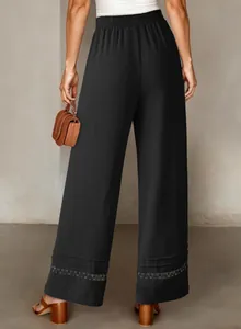 Detailed back view of black wide-leg trousers showing elastic waist and lace hem decoration.