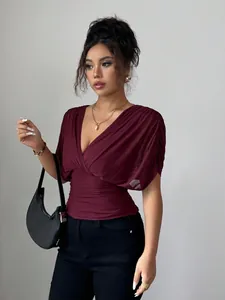 Detail view of elegant burgundy deep V-neck top featuring pleated flying sleeves design