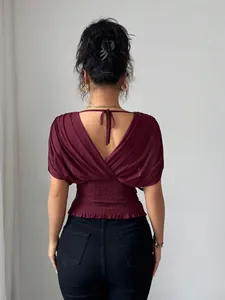 Detailed back view of a burgundy V-neck top with smocked waist and flutter sleeves