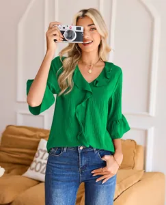 Stylish green loose V-neck blouse with elegant ruffle trim and flared sleeves on model