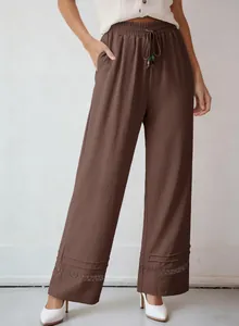Detailed view of women's brown high-waist wide-leg pants with lace hem and drawstring