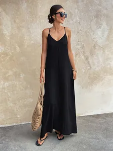 Elegant black V-neck spaghetti strap maxi dress shown in a full-length street style pose