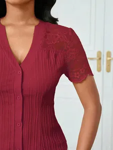 Close-up of burgundy V-neck top with lace shoulder detail and pleated texture