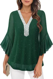 Close-up of elegant dark green V-neck top with silver sequins and flared bell sleeves.