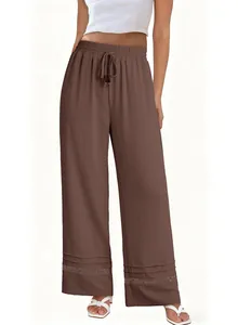 Close-up of brown high-waisted wide-leg pants featuring a delicate lace hem detail