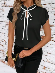Close-up of elegant black short sleeve top featuring white ruffle collar and tie detail