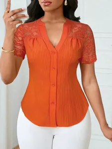 Macro view showing the pleated texture and lace embroidery on this orange blouse