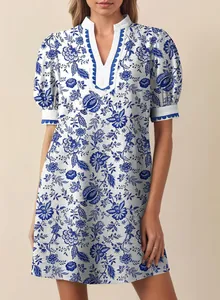 Detail view of a blue and white floral vacation dress featuring a V-neck and puff sleeves.