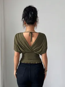 Chic olive green smocked waist top with a stylish deep V-back design and flutter sleeves