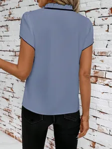 Back view of a blue short-sleeved blouse with ruffled collar and black piping detail