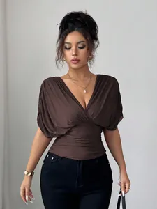 Close-up of deep V-neck dark brown women's top with pleated waist and small cap sleeves