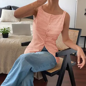 Elegant pink sleeveless button-up smocked top for women shown in a modern home setting.