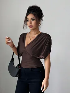 Detail shot of a stylish dark brown deep V-neck ruched top with short sleeves on model