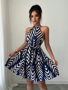 Detail view of a halter neck sleeveless mini dress with blue wave stripe print and tie waist.