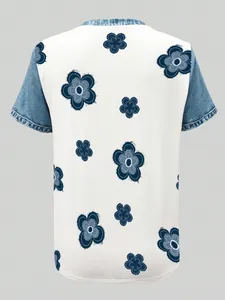 Back view of women's short sleeve top with blue floral print and denim patchwork details