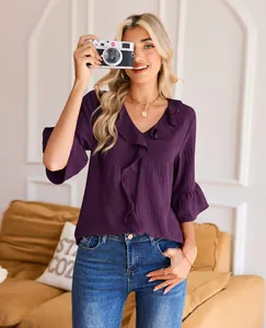 Detailed shot of purple ruffled V-neck blouse showing textured fabric and sleeve detail