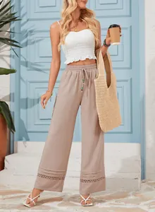 Detailed view of high-waisted wide-leg pants with elegant hollow-out lace hem design