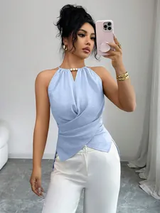 Modèle portant un haut bleu clair à licou croisé à la taille avec un pantalon blanc.