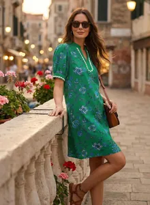Detail of green floral short-sleeve V-neck dress on model in scenic vacation street