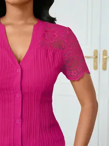 Close-up detail of fuchsia blouse showing intricate floral lace sleeve and matching buttons.
