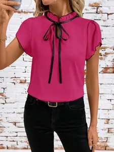 Close-up view of vibrant hot pink blouse with ruffled collar and black tie-up ribbon