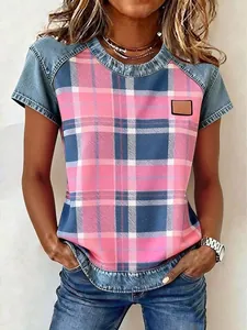 Detail of women's round neck top with pink plaid print and denim patchwork sleeves