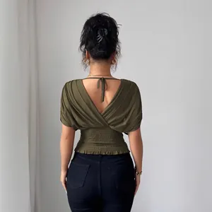 Fashionable olive green deep V-neck top with smocked waist and flutter sleeves