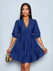 Detail of dark blue V-neck tiered dress with puff sleeves and ruffled hem design
