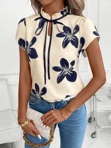 Elegant short sleeve blouse with ruffled collar, navy floral print, and delicate tie-neck detail.