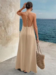 Detailed view of backless halter dress with beaded T-strap and crinkled fabric texture