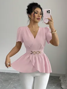 Dettaglio di una camicetta a portafoglio rosa con scollo a V ed elegante fibbia dorata