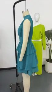 Dettaglio laterale di un abito a balze senza maniche in chiffon verde petrolio su manichino