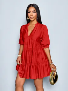 Detail view of a vibrant red deep V-neck tiered mini dress with puff sleeves.