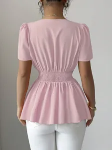 Vista posteriore di una camicetta rosa a maniche corte con vita elastica a peplo.