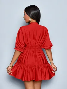 Back view of a red pleated mini dress featuring puff sleeves and tiered skirt texture