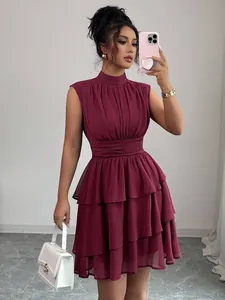 Abito corto a balze bordeaux senza maniche con collo alto e vita arricciata.