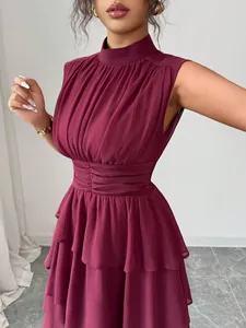 Dettaglio ravvicinato dell'abito a balze senza maniche bordeaux con texture plissettata