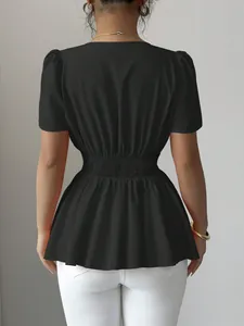 Vista posteriore di un top peplum nero a maniche corte con vita elastica a nido d'ape