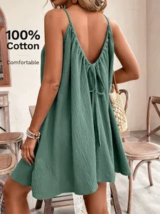 Gros plan d'une robe verte en coton dos nu avec détail à nouer et texture douce