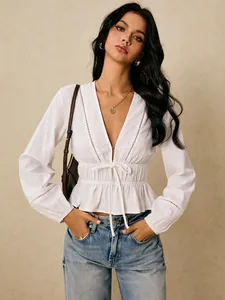 Detail view of white deep V-neck blouse with lace hollow-out and peplum hem.